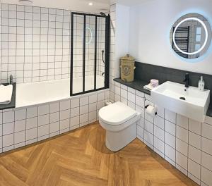 ein Badezimmer mit einem WC, einem Waschbecken und einem Spiegel in der Unterkunft Ilfracombe Townhouse: restored historic home in Ilfracombe