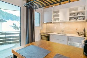 a kitchen with a table and a large window at Apartment next to Titlis Station in Engelberg