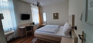 a small bedroom with a bed and a sink at Pension Post Rüdesheim in Rüdesheim am Rhein