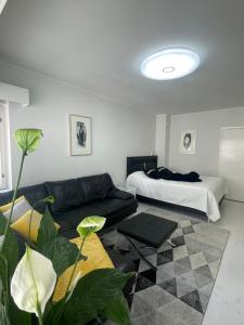 a living room with a couch and a bed at Go Happy Home Apartments in Helsinki