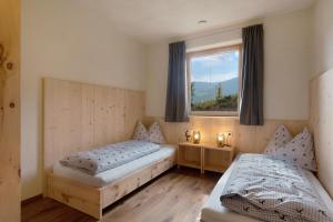 1 Schlafzimmer mit 2 Betten und einem Fenster in der Unterkunft Ratscheinerhof App Gipfelglück in Latzfons