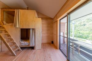 a treehouse with a bunk bed in a room with a large window at Male Only Dormitory Guest House Amami Long Beach2 Vacation STAY 37987v in Amami