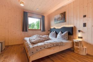 um quarto com uma cama num quarto com uma janela em Ratscheinerhof App Waldruhe em Lazfons