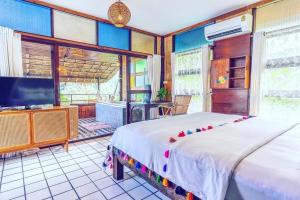 Schlafzimmer mit einem Bett und einem Flachbild-TV in der Unterkunft Cookies Salad Resort in Salad Beach