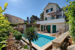 una villa con piscina frente a una casa en Villa Demi, en Pražnice