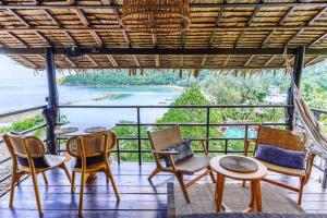 a balcony with chairs and tables and a view of the ocean at Cookies Salad Resort in Salad Beach