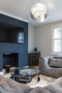 een woonkamer met een bank en een glazen tafel bij Spacious 2 bedroom apartment with beautiful garden in Brighton & Hove