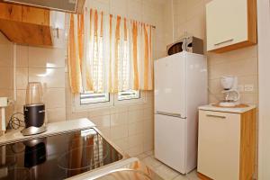 małą kuchnię z białą lodówką i oknem w obiekcie Sunshine Apartment Doda w mieście Vela Luka