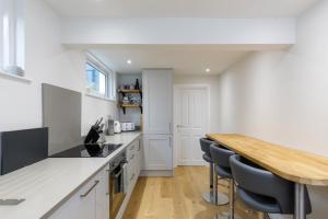 een keuken met witte werkbladen en een houten aanrecht bij Spacious 2 bedroom apartment with beautiful garden in Brighton & Hove