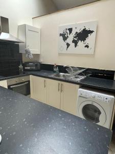 a kitchen with a sink and a washing machine at Flat 2 Chestergate in Macclesfield