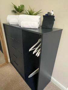 a black dresser with towels on top of it at Flat 2 Chestergate in Macclesfield