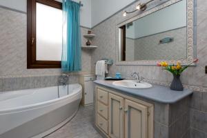 een badkamer met een bad, een wastafel, een bad en een spiegel bij I Tre Golfi - Appartamenti a 800 mt dal centro in San Vito lo Capo