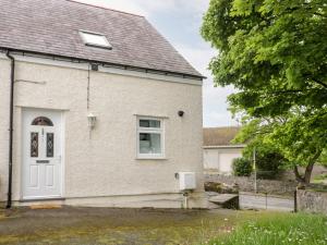 una casa de ladrillo blanco con puerta blanca en 1 Old Kingdom Hall, en Amlwch