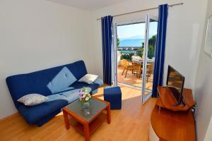 a living room with a blue couch and a table at Villa Dalmatina in Živogošće