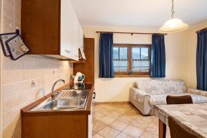 una cucina e un soggiorno con lavandino e divano di Appartamento Greta Baita Mauri a Livigno