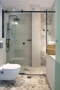 a bathroom with a glass shower and a toilet at Edward Art Boutique Hotel in Nydri