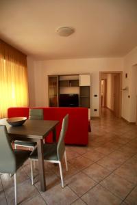 een woonkamer met een rode bank en een tafel en stoelen bij La Torre in Tirano