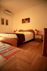 een slaapkamer met een groot bed en een houten vloer bij La Torre in Tirano