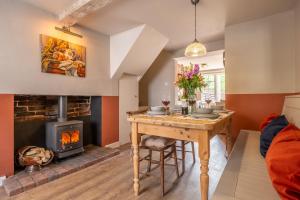 a living room with a table and a fireplace at Heavenly 16th century cottage in pretty rural village - Swan's Nest in Boxford