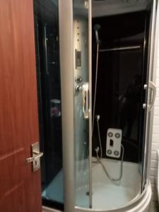 una ducha con puerta de cristal y altavoz en apartamente si studio joylife, en Costinesti