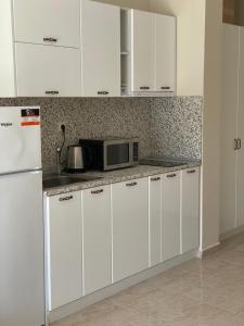 a kitchen with white cabinets and a microwave at Sea Dreams Studio in Sveti Vlas