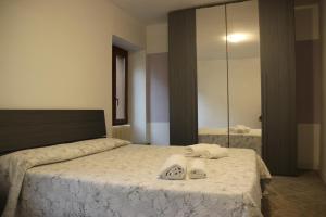 a bedroom with a bed with two towels and a mirror at Homemade Lake in Desenzano del Garda