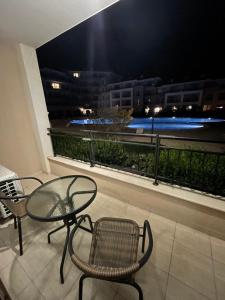 a glass table and chairs on a balcony at night at Sea Dreams Studio in Sveti Vlas
