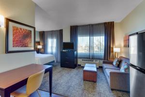 a hotel room with a couch and a bed at Staybridge Suites San Angelo by IHG in San Angelo