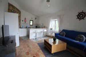a living room with a blue couch and a table at Casa do Milho in Carvoeiro