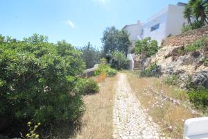 a dirt road leading up to a building on a hill at Casa do Milho in Carvoeiro