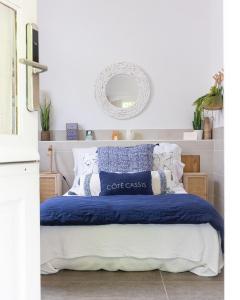 1 dormitorio con 1 cama con almohadas azules y blancas en Hotel de La Plage - Mahogany, en Cassis