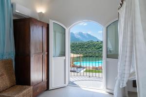 a bedroom with a door open to a view of a pool at Hotel Villa Cedrino in Dorgali