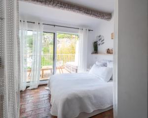 a bedroom with a white bed and white walls at Hotel de La Plage - Mahogany in Cassis