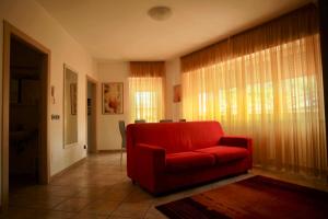 a living room with a red chair and a window at La Torre in Tirano