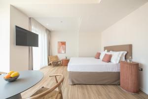 una camera da letto con un letto, un tavolo e una TV di Ceramian Athens ad Atene