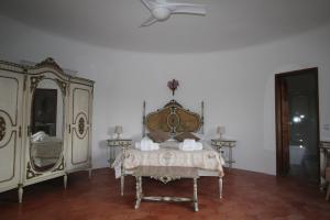 a bedroom with a bed and mirrors and a ceiling fan at Casa do Milho in Carvoeiro