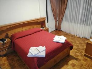 - une chambre avec un lit rouge et 2 serviettes dans l'établissement Amplio departamento en la zona central norte 1B, à Cochabamba