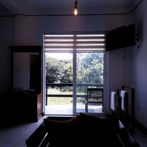 a living room with a large window with a view at Royal Crown Residence in Talawatugoda