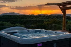 a jacuzzi tub with a sunset in the background at Hotel Villa Cedrino in Dorgali