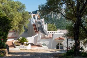 a white house with stairs and trees at Hotel Villa Cedrino in Dorgali