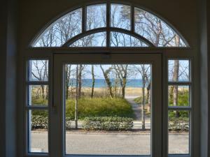 una finestra aperta con vista sull'oceano attraverso di essa di MEERBLICK-MAISONETTE Ostseebad Kühlungsborn a Kühlungsborn