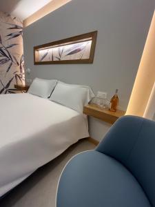 a bedroom with a bed and a blue chair at ELISEO PALACE TROPEA in Tropea