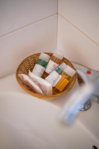 uma cesta de produtos de higiene pessoal num balcão na casa de banho em Almira Inn em Chora, Ios