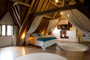 een slaapkamer met een bed in een kamer met houten plafonds bij Château de Bois Charmant in Les Nouillers