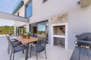 a dining room with a table and chairs and a fireplace at Villa Grisi in Vižinada