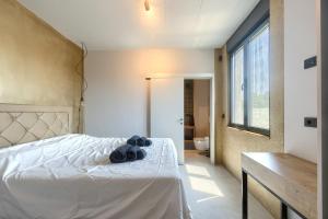 a bedroom with a white bed and a bathroom at Villa Grisi in Vižinada