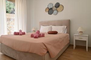 een slaapkamer met een groot bed met roze schoenen erop bij Villa Ioanna in Liapades +16 foto's