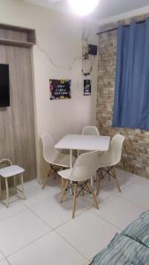 a dining room with a white table and chairs at Apartamento em Praia Grande in Praia Grande