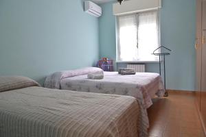 1 dormitorio con 2 camas y ventana en Casa Serena, en Ivrea