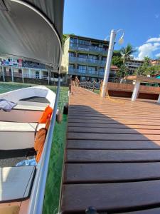 a boat is parked next to a wooden dock at Pousada toca do cambu in Angra dos Reis